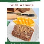 A slice of banana bread on a white plate with orange slices. A loaf of cut bread on a wood cutting board is in the background with a knife. "Spiced Banana Bread with Walnuts" is at the top
