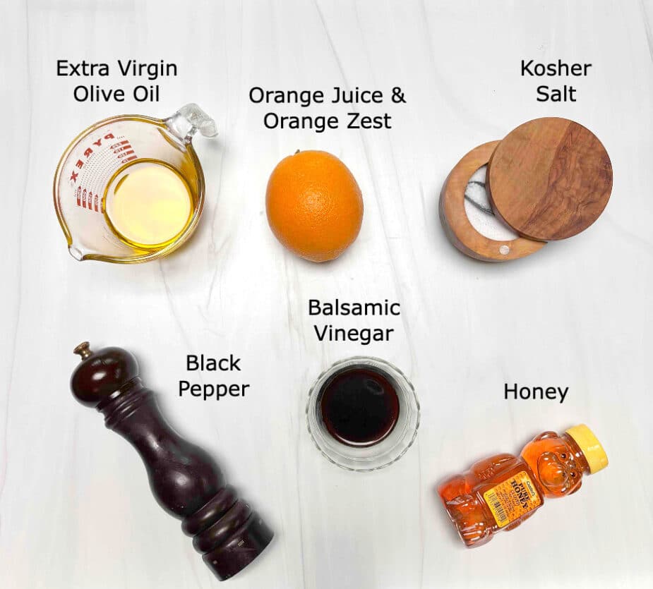 Ingredients to make the orange balsamic vinaigrette dressing on a marble counter