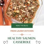 A square glass casserole dish filled with wild rice, salmon and vegetables that is topped with almonds. An orange linen and spoon are on the side. Hearts are on the side of the title "Healthy Salmon Casserole"