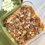 A square glass casserole pan filled with brown and wild rice salmon casserole topped with crunchy almonds. An easy weeknight meal is called out on the side.