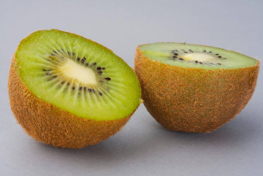 kiwi a kiwi cut in half on a grey counter
