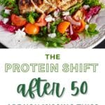 A white decorative plate filled with a colorful salad with a grilled chicken breast sliced on top