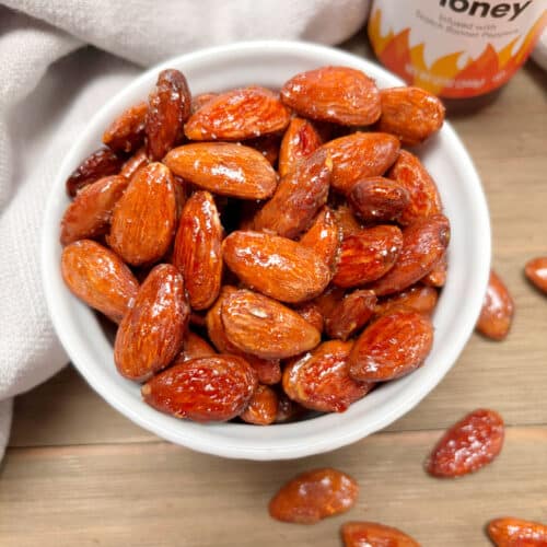 A white bowl filled with hot honey almonds