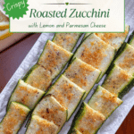 A platter filled with crispy zucchini strips with a bowl of parmesan cheese and lemon slices in the background