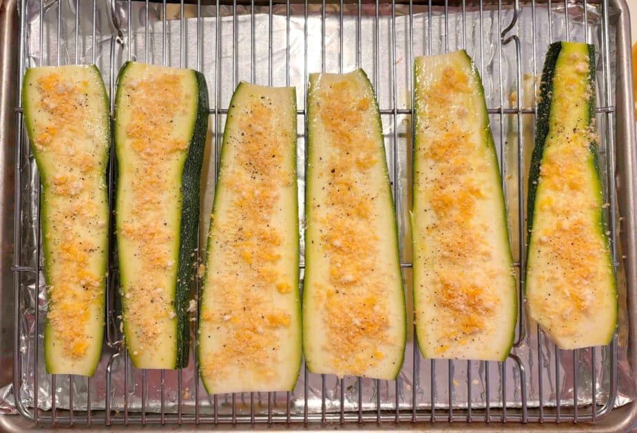 Zucchini prepped Sliced zucchini on a rack with Parmesan cheese, lemon zest and garlic powder sprinkled over top.