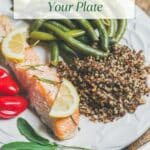 A plate filled with roasted salmon, beans, tomatoes, and quinoa